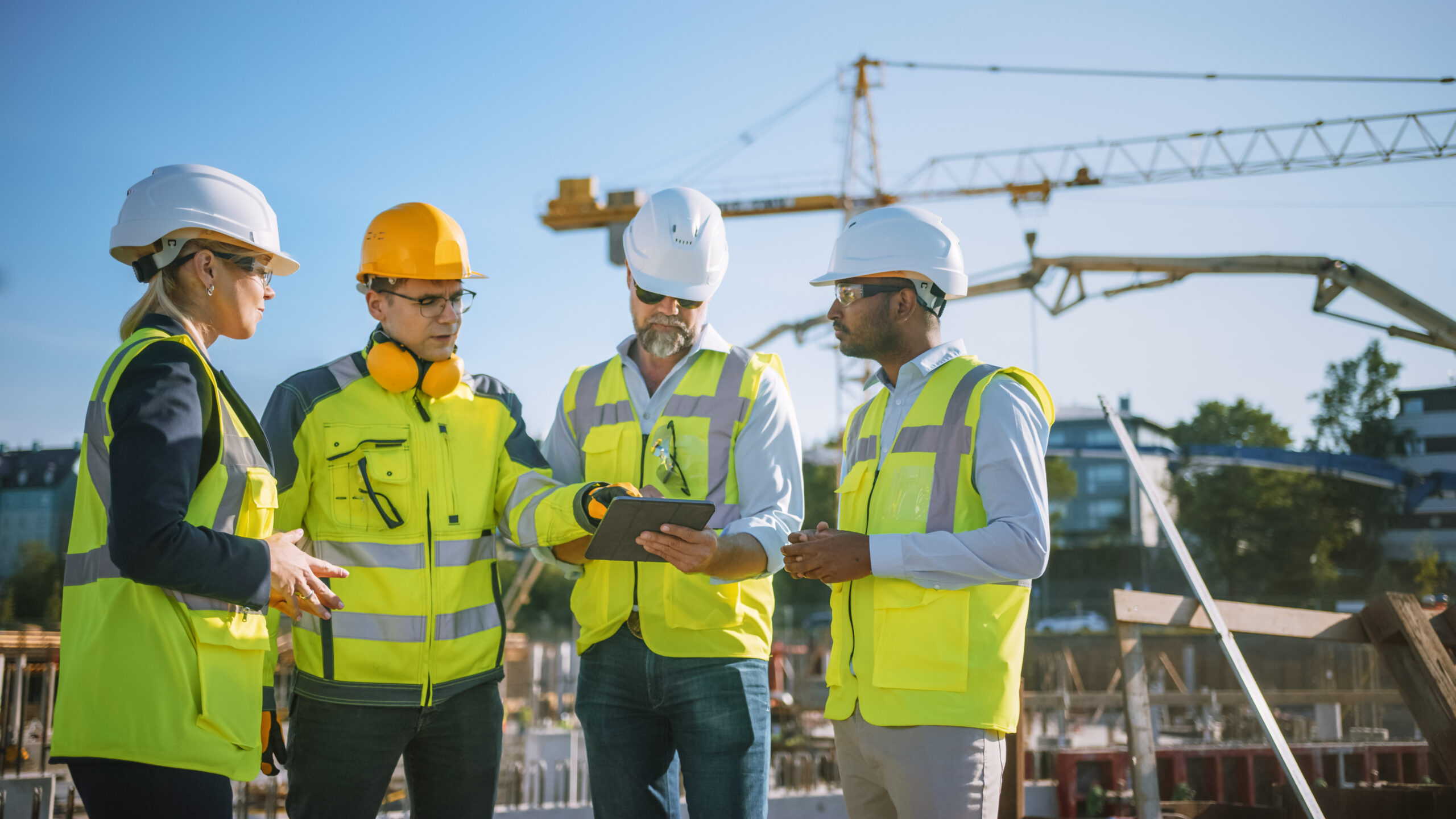 Diverse Team of Specialists Use Tablet Computer on Construction